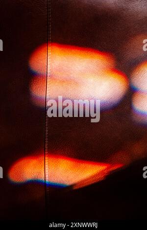 Farbenfrohes Sonnenlicht durch Buntglasfenster beleuchtet teure Ledersessel Stockfoto