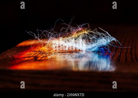 Refraktioniertes Sonnenlicht durch Buntglasfenster beleuchtet verschiedene Faserfäden Stockfoto