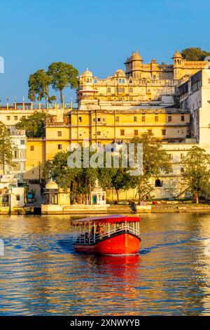 Touristenboot auf dem See Pichola mit dem Stadtpalast im Hintergrund, Udaipur, Rajasthan, Indien, Südasien, Asien Stockfoto