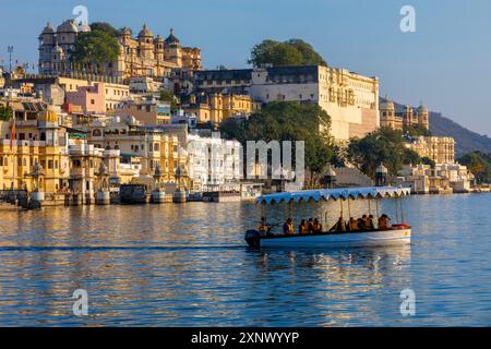 Touristenboot auf dem See Pichola mit dem Stadtpalast im Hintergrund, Udaipur, Rajasthan, Indien, Südasien, Asien Stockfoto