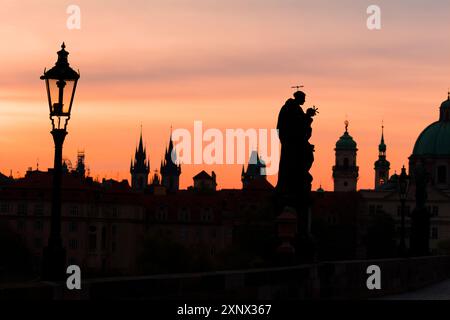 Silhouetten einer Statue an der Karlsbrücke und Türme bei Sonnenaufgang, UNESCO-Weltkulturerbe, Prag, Tschechien (Tschechien), Europa Stockfoto