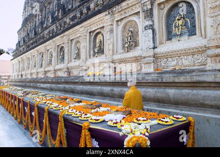 Blumenopfer und ein Mönch im buddhistischen Mahabodhi Mahabihara Tempel (große Stupa), Bodh Gaya, UNESCO-Weltkulturerbe, Bihar, Indien, Asien Stockfoto