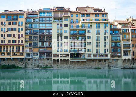 Wunderschöner Blick auf alte, farbige italienische Häuser am ruhigen Wasser des Flusses Arno im historischen Teil von Florenz, Italien. Stockfoto