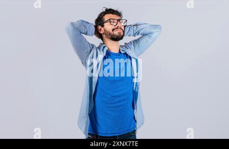 Entspannter, lächelnder Mann mit isolierten Händen hinter dem Kopf. Entspannter Mensch mit Händen hinter dem Kopf, zufrieden isoliert Stockfoto