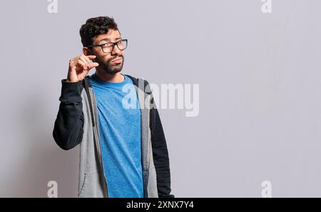 Person zeigt eine kleine Menge mit den Fingern, Menschen gestikulieren mit der Hand zeigen etwas kleines mit den Fingern. Mann misst etwas Stockfoto