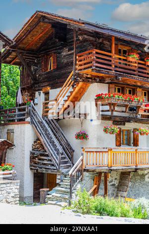 Hölzerne Außentreppe auf einem alten Haus, Blumenkästen vor Fenstern und Balkonen, historisches Dorfzentrum, Grimentz, Val d'Anniviers, Wallis Stockfoto