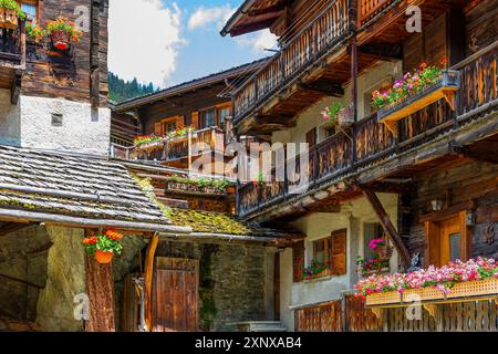 Eingebettete alte Holzhäuser mit Blumenkästen vor Fenstern und Balkonen, historisches Dorfzentrum, Grimentz, Val d'Anniviers, Walliser Alpen, Kanton Stockfoto