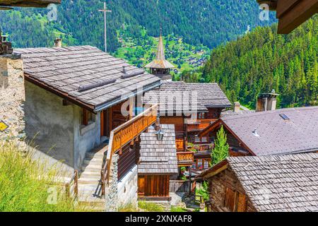 Alte Holzhäuser mit Holzschindeldächern, Kirche Saint Theodule im hinteren Teil, historisches Dorfzentrum, Grimentz, Val d'Anniviers Stockfoto