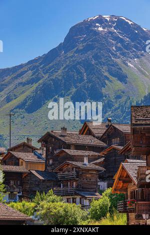 Eingebettete alte Holzhäuser im historischen Zentrum von Grimentz, mit dem Gipfel der Scex de Marenda im Hintergrund, Val d'Anniviers, Walliser Alpen Stockfoto