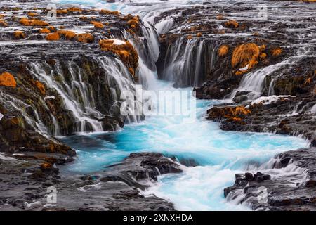 Die unglaublich farbenfrohen Details des berühmten Bruarfoss Wasserfalls mit seinem türkisfarbenen Wasser und goldenen Gras, aufgenommen an einem kalten Wintertag, Island, Pol Stockfoto