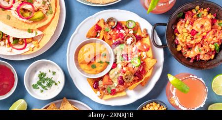 Mexikanisches Essen Panorama, eine flache Lage. Nachos, Tortillas, Paloma Cocktails und andere Gerichte, von oben geschossen Stockfoto