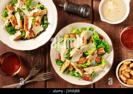 Caesar Salat, Top Shot mit Wein, Pfeffer und der klassischen Sauce, auf einem dunklen rustikalen Holzhintergrund Stockfoto