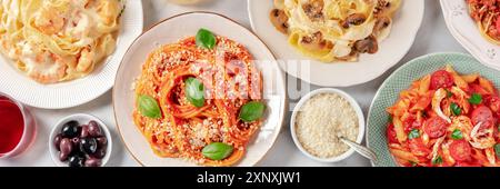 Panorama der italienischen Küche. Verschiedene Pastas, Oliven und Parmesankäse, von oben auf weißem Marmorboden geschossen Stockfoto