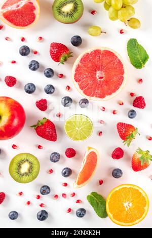 Frisches Obst. Zitrusfrüchte, Heidelbeeren, Erdbeeren und Minze, oben flach lag auf einem weißen Hintergrund erschossen Stockfoto