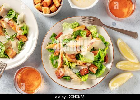 Hähnchen Caesar Salat, über dem Kopf flach Lay Shot mit Wein und Zitronen Stockfoto