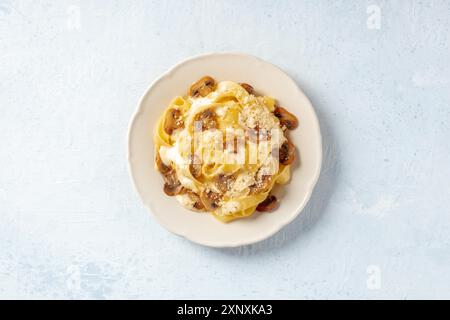 Pappardelle Pasta mit Pilzen, Sahnesauce und geriebenem Parmesan-Käse, darüber liegend flach hingelegt Stockfoto