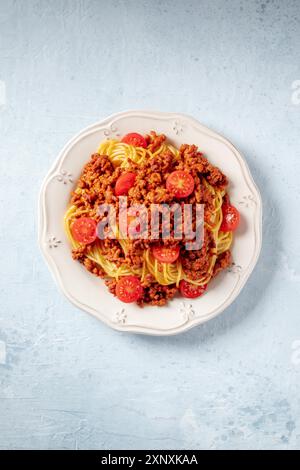 Spaghetti Bolognese Pasta mit Kirschtomaten, darüber flach auf Schiefer-Hintergrund geschossen Stockfoto