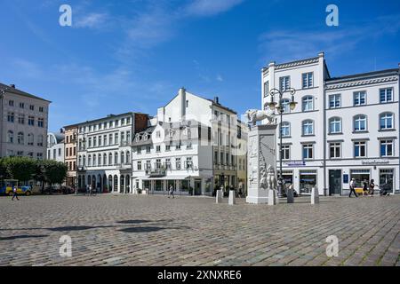 Schwerin, Deutschland, 29. Juli 2024: Weiße Gebäude und das Löwendenkmal des Bildhauers Peter Lenkon auf dem Marktplatz in der historischen Altstadt von Sch Stockfoto