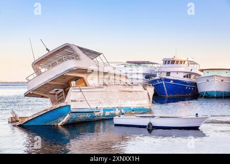 Altes hölzernes Vergnügungsboot auf dem Meer sinkt im Hafen Stockfoto