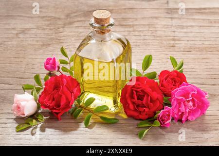 Rose ätherisches Öl in Glas Flasche auf hölzernen Tisch Stockfoto