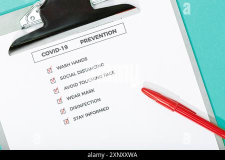 Coronavirus-Ratschläge oder Präventionskonzept. Draufsicht einer COVID-19-Prüfliste und Sicherheitsausrüstung Stockfoto