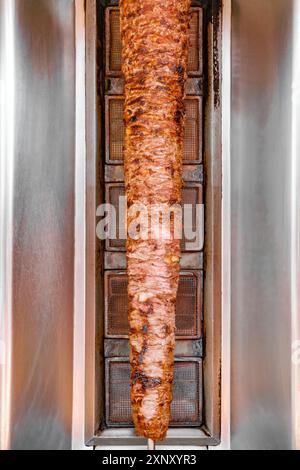 Shawarma grillt vertikal aufgespießte Schichten von saftigem Hühnerfleisch, das in einem Kebab-Sandwich serviert wird Stockfoto