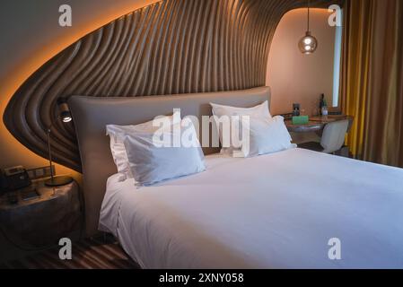 Luxuriöses Hotelzimmer mit modernem Design und kunstvollem Holzkopfteil Stockfoto