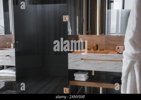 Luxuriöses Hotelbad mit Marmorablage und goldfarbenen Armaturen Stockfoto