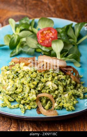 Bayerischer Spinat-Spätzle auf blauem Teller Stockfoto