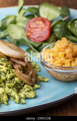 Spinatspätzle auf blauem Teller Stockfoto