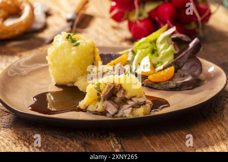 Gefüllte Kartoffelknödel mit Salat auf Holz Stockfoto