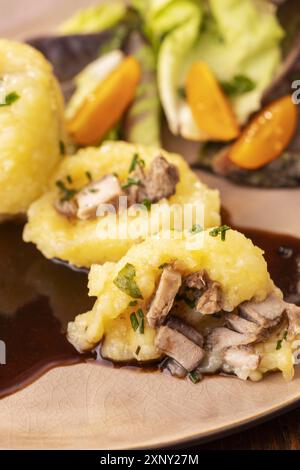 Gefüllte Kartoffelknödel mit Salat auf Holz Stockfoto