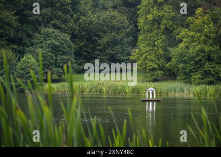 Kleine künstliche Insel mit weißem Pavillon für Wasservögel auf dem See im idyllischen Landschaftspark Putbus mit Schilf am Ufer, groß alt Stockfoto