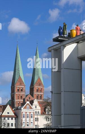 Marienkirche oder Marienkirche mit zwei Türmen und den Skulpturen, die Fremde genannt werden, auf dem Dach des Musik- und Kongresssaals (Muk) in Lübeck Stockfoto