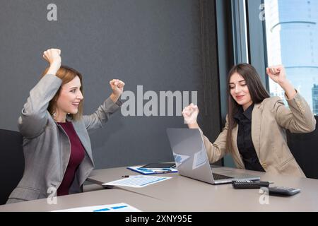 Zwei glückliche Geschäftsfrauen arbeiten im Büro Stockfoto