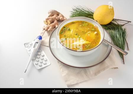 Bleiben Sie gesund in der Kälte- und Grippesaison mit Hühnersuppe, Ingwer und Zitrone als Hausmittel, Faserthermometer und Tabletten für die medizinische Versorgung, Licht Stockfoto