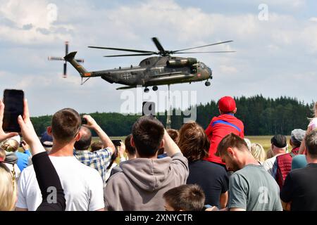 Zuschauer beobachten und fotografieren einen Transporthubschrauber CH-53 der Bundeswehr während einer Flugvorführung beim Tag der Bundeswehr 2024 in Faßberg Niedersachsen der Tag der Bundeswehr findet jährlich statt. An diesem Tag öffnen Deutschlandweit ca. 10 Kasernen Ihre Tore und laden die Bevölkerung ein, hinter die Kulissen zu schauen. Faßberg Niedersachsen Deutschland *** Zuschauer beobachten und fotografieren einen CH 53 Transporthubschrauber der Bundeswehr während einer Flugdemonstration zum Tag der Bundeswehr 2024 in Faßberg Niedersachsen dem Tag der Bundeswehr Stockfoto