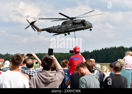 Zuschauer beobachten und fotografieren einen Transporthubschrauber CH-53 der Bundeswehr während einer Flugvorführung beim Tag der Bundeswehr 2024 in Faßberg Niedersachsen der Tag der Bundeswehr findet jährlich statt. An diesem Tag öffnen Deutschlandweit ca. 10 Kasernen Ihre Tore und laden die Bevölkerung ein, hinter die Kulissen zu schauen. Faßberg Niedersachsen Deutschland *** Zuschauer beobachten und fotografieren einen CH 53 Transporthubschrauber der Bundeswehr während einer Flugdemonstration zum Tag der Bundeswehr 2024 in Faßberg Niedersachsen dem Tag der Bundeswehr Stockfoto