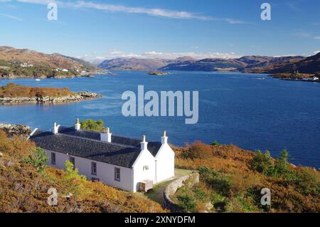 Weißes Haus auf einem Loch umgeben von hellen Herbstfarben in der Natur, Oktober, Kyle of Lochalsh, Hebriden, Isle of Skye, Hebriden, Schottland, Vereinigte Staaten Stockfoto