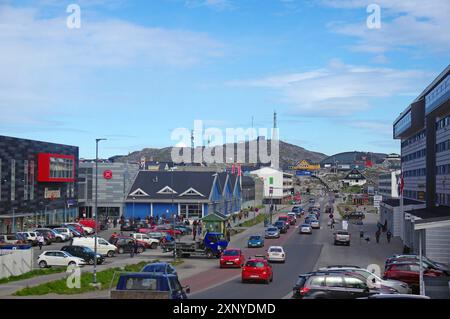 Blick auf die Stadt mit Autos auf der Straße und modernen Gebäuden entlang der Straße, Hügel im Hintergrund, Hauptstadt, Nuuk, Grönland, Dänemark Stockfoto