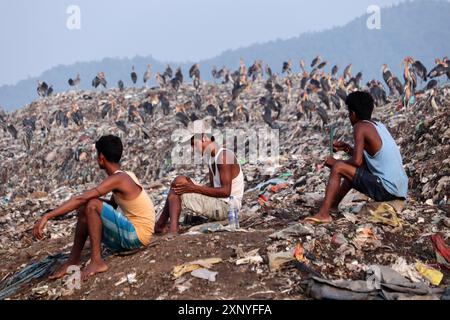 Ragpicker, der am Vorabend des Weltumwelttages in Guwahati, Assam, Indien, am Freitag, den 4. Juni neben einem Müllhaufen auf der Müllhalde in Boragaon sitzt Stockfoto