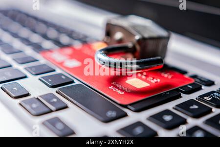Vorhängeschloss oben auf der Kreditkarte auf der Laptop-Tastatur. Öffnen Sie das Vorhängeschloss mit der Kreditkarte auf der Tastatur. Das Konzept des Diebstahls von Informationen auf Kreditkarten Stockfoto