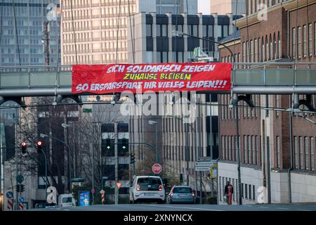 Großes Banner ruft Menschen zum Verbleib zu Hause auf, fordert Solidarität, Alfredstrasse, B224, Auswirkungen der Coronavirus-Pandemie in Deutschland, Essen Stockfoto