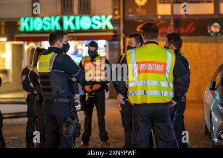 Zusammenarbeit mit dem Amt für öffentliche Ordnung und der Polizei, Überprüfung der Einhaltung der Corona-Regeln, Unterrichtung, Pflichtmasken, Gruppe Stockfoto