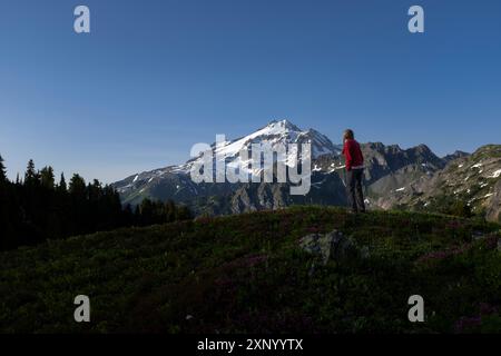 WA24973-00....WASHINGTON - Frau, die den Glacier Peak von einem Hügel nördlich des Red Pass aus betrachtet, Glacier Peak Wilderness, Mount Baker Snoqualmie National for Stockfoto