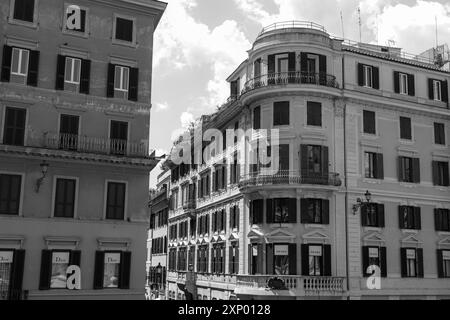 Die Geschäfte von Dior und Prada an der Via dei Condotti, einer schicken Einkaufsstraße, die von der Spanischen Treppe aus in Schwarz-weiß betrachtet wird Stockfoto