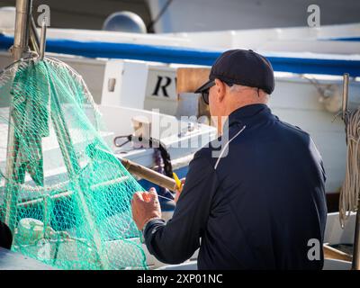 Fischer repariert sein Netz in Rovinj Kroatien Stockfoto