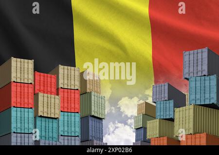 Belgische Flagge und großer Stapel von Frachtcontainern in Docks mit Himmelshintergrund aus nächster Nähe Stockfoto