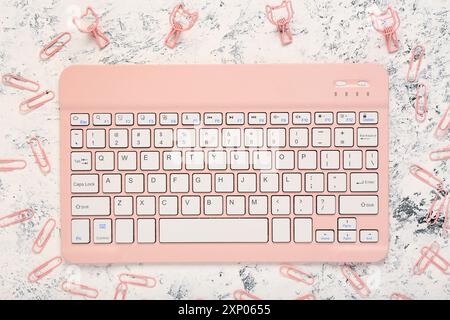 Stilvolle pinke Tastatur und Clips auf weißem grundigem Hintergrund Stockfoto