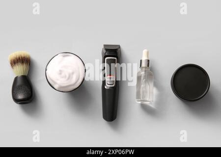 Moderner Trimmer und Rasierzubehör auf grauem Hintergrund Stockfoto